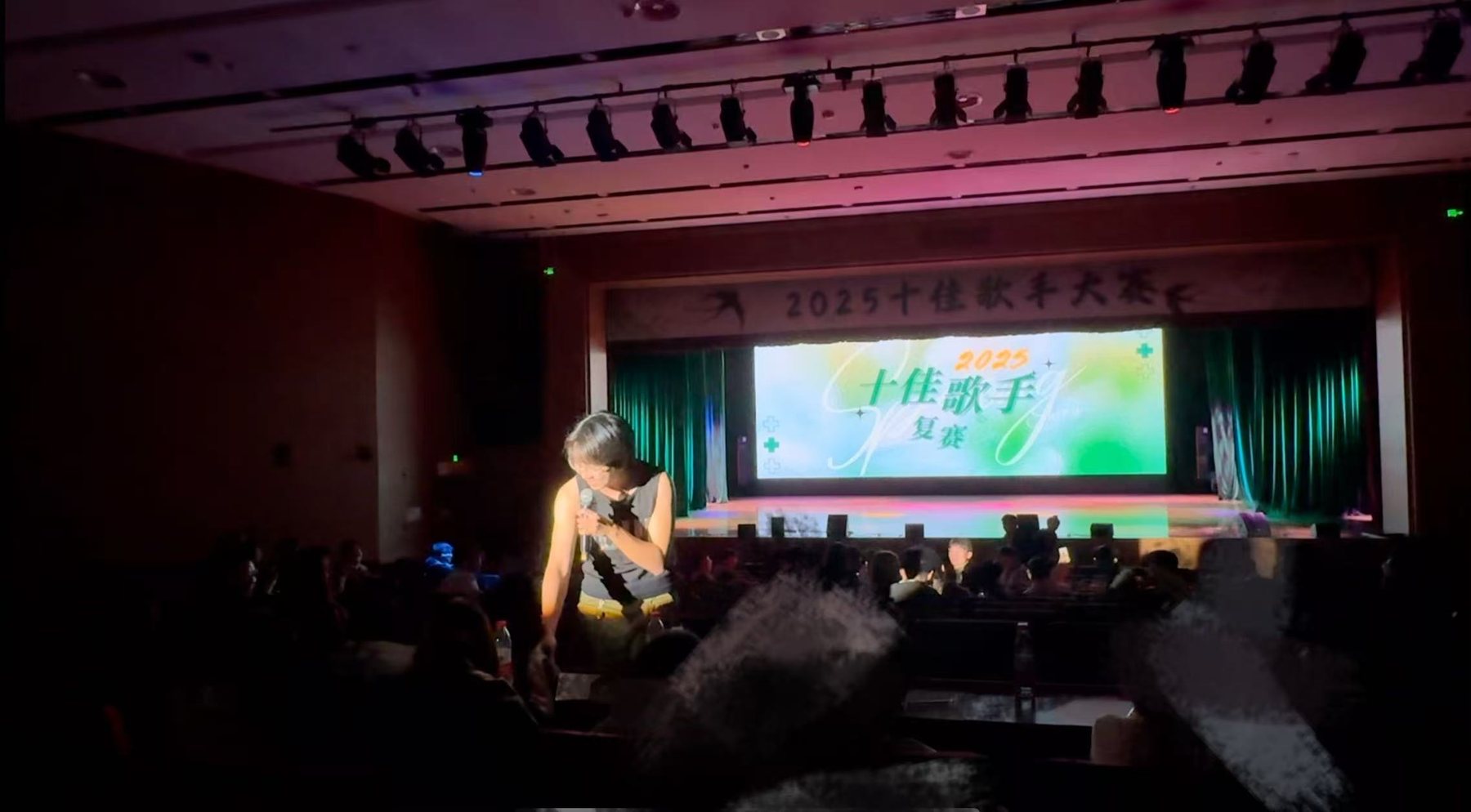 Wide view of Zhaoyang Yuan performing in the 2025 Campus Singer Competition