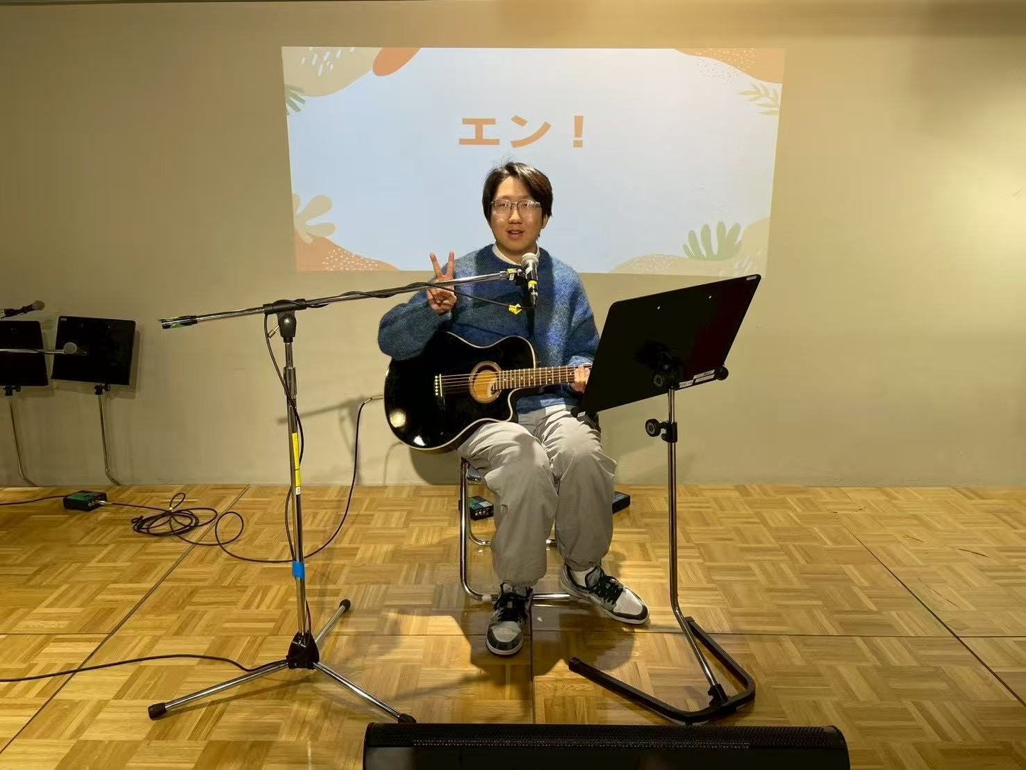 Zhaoyang Yuan seated with an acoustic guitar during his club debut